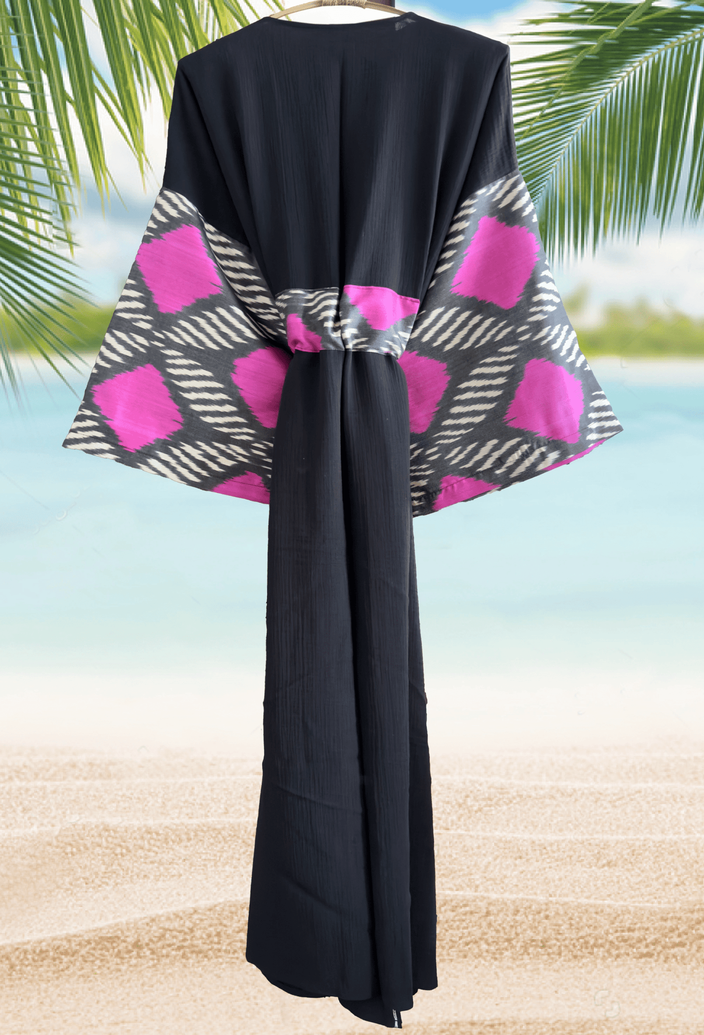 Woman wearing a black double gauze muslin kimono robe with handwoven silk ikat sleeve detail – bohemian beachwear look