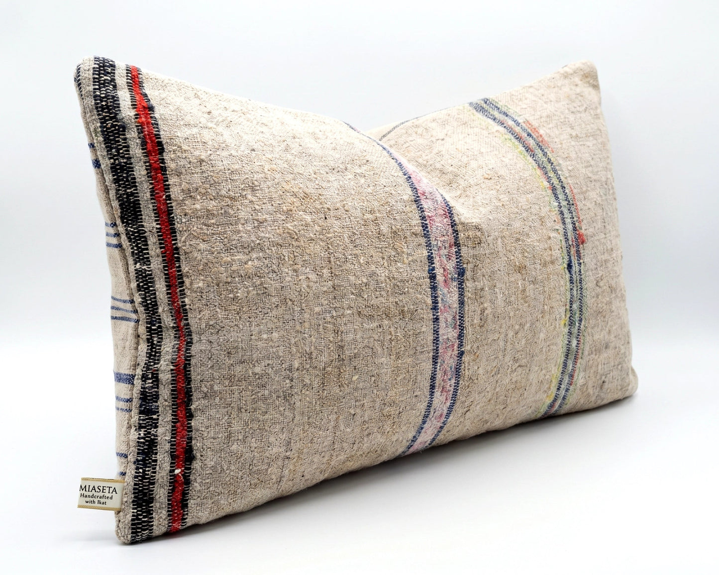 handwoven Anatolian grain sack cushion in neutral tones with red and blue stripes