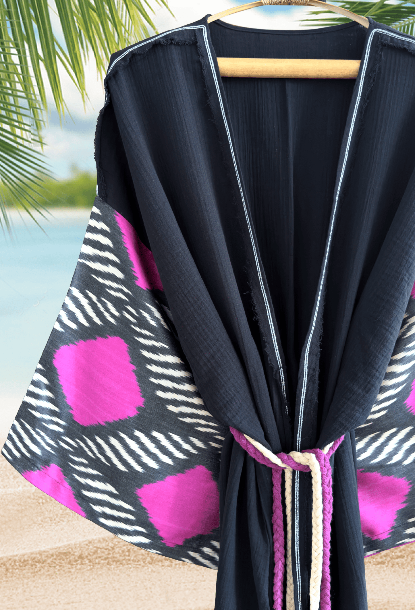 Woman wearing a black double gauze muslin kimono robe with handwoven silk ikat sleeve detail – bohemian beachwear look
