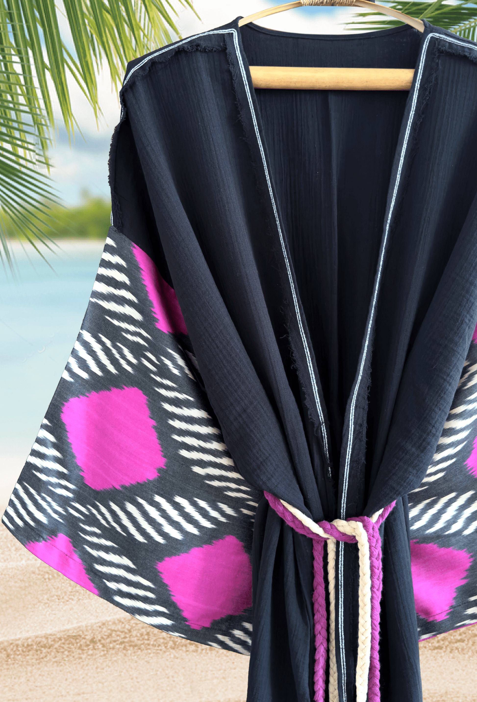 Woman wearing a black double gauze muslin kimono robe with handwoven silk ikat sleeve detail – bohemian beachwear look