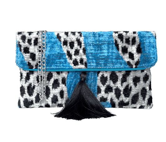 Blue silk velvet ikat clutch bag with black and white pattern and tassel on a white background