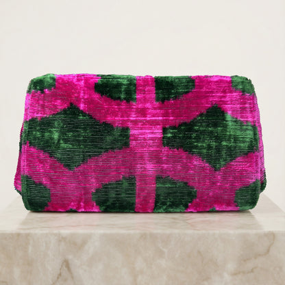 Pink and green patterned clutch bag on a light background