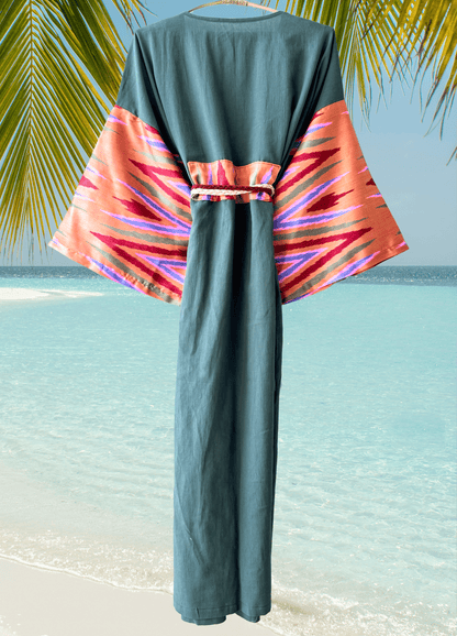 Muslin green dress with colorful patterned silk ikat sleeves on a beach background