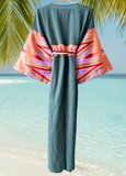 Muslin green dress with colorful patterned silk ikat sleeves on a beach background