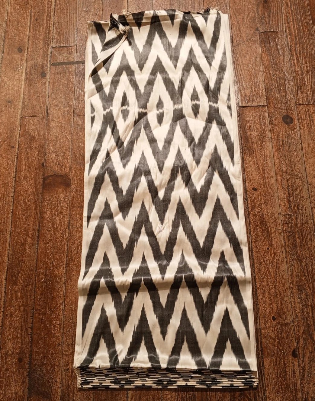 Folded fabric with a black and white zigzag pattern on a wooden surface