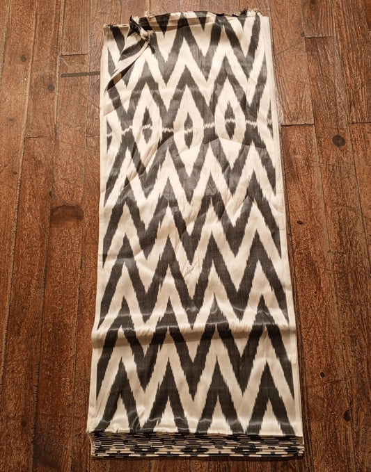 Folded fabric with a black and white zigzag pattern on a wooden surface