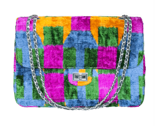 Luxury silk velvet ikat jumbo bag featuring bold multicolor patterns, handcrafted quality, and a chic chain strap. The perfect statement designer handbag for elevating any outfit with timeless artisanal elegance.