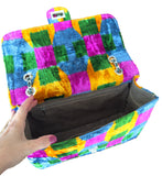 Colorful checkered silk velvet ikat jumbo bag with a hand holding it open on a white background