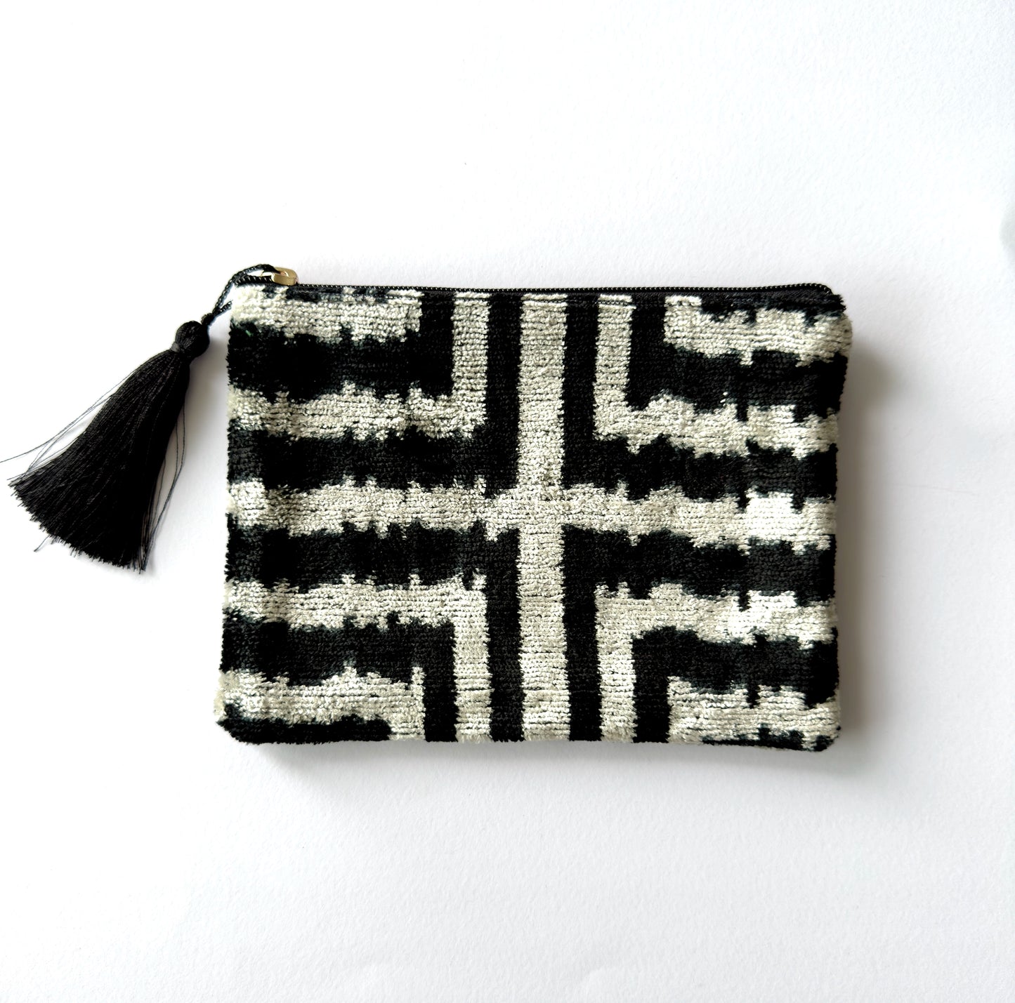 Black and white patterned pouch with a tassel on a white background