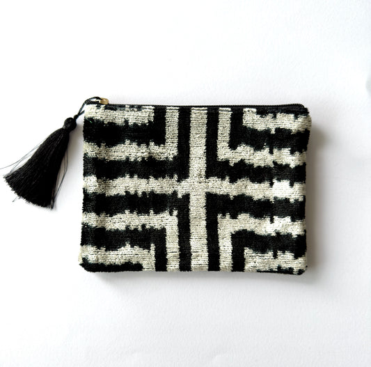 Black and white patterned pouch with a tassel on a white background
