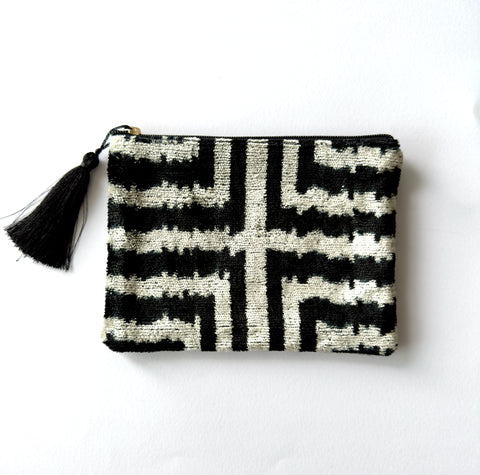 Black and white patterned pouch with a tassel on a white background