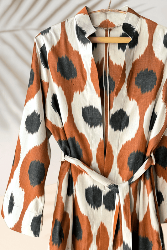 handwoven silk ikat caftan, a perfect ikat dress for gifting. Crafted using traditional Uzbekistan ikat woven techniques, this stunning ikat wear features bell sleeves, side and sleeve slits, and pockets on both sides. Available in elegant black and grey, this ikat caftan beautifully blends bohemian style with ethnic charm, making it the ideal gift for anyone who appreciates unique ikat fashion. Embrace the artistry of handmade ikat clothing and make a statement