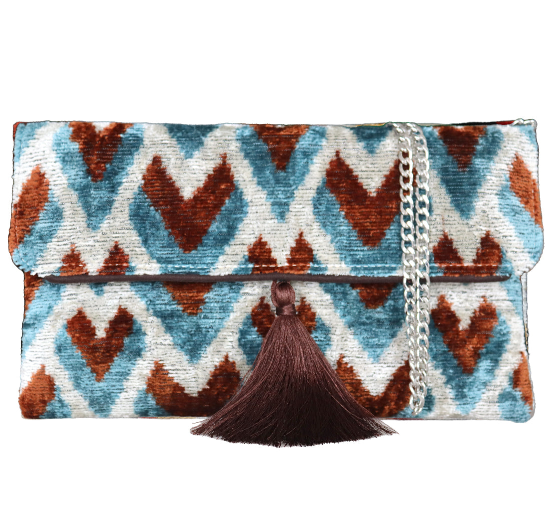 Silk velvet ikat handmade clutch bags, featuring a stylish chain shoulder strap included. Explore our exclusive collection, expertly handcrafted by skilled artisans in Istanbul's Grand Bazaar, Turkey, using traditional Uzbek fabrics. Specially crafted with handwoven silk velvet ikat, each piece showcases vibrant colors and ethnic patterns, accented by special handmade details. Perfect for ethical fashion enthusiasts and holiday shopping, including Valentine's Day gifts, Black Friday sales, discounts, and Mo