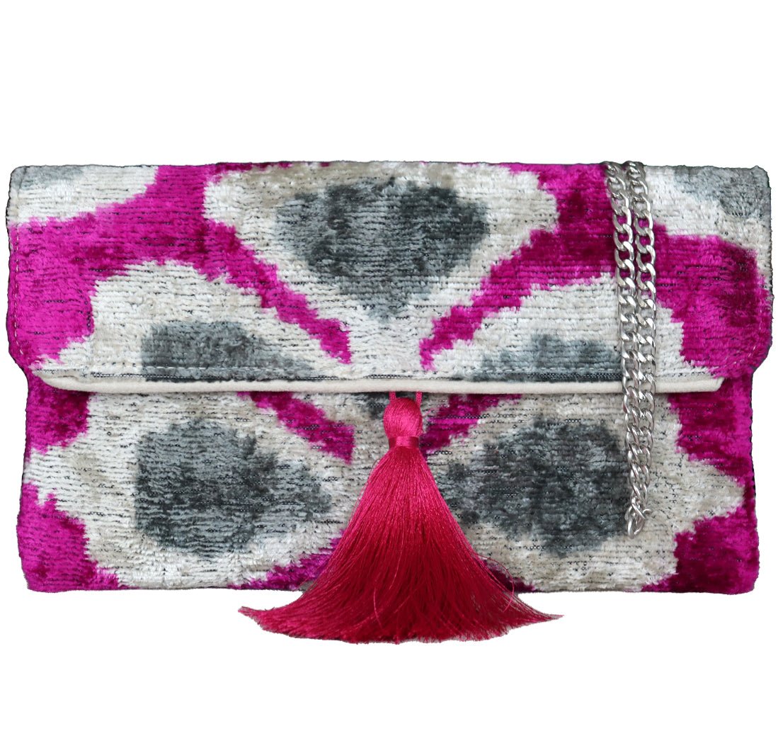 Wholesale and retail Silk ikat pink and grey Velvet Clutch Bags, expertly handcrafted using traditional Uzbek fabrics. Explore our exclusive collection of unique clutch bags, specially crafted using handwoven silk velvet ikat with vibrant colors and ethnic patterns. Each one carries its own uniqueness, accentuated by special handmade details. Produced by skilled artisans in Istanbul's Grand Bazaar, Turkey, these bags feature a stylish chain shoulder strap included and are perfect for ethical fashion